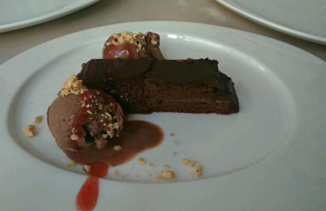 Tarta de chocolate rellena de mermelada y con cubertura de chocolate. Acompañada de una bola de helado.